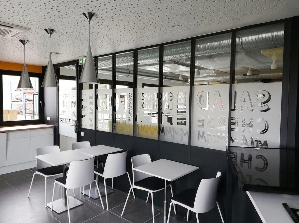 Véhicule utilitaire blanc avec design graphique vert, noir et hexagonal sur fond neutre